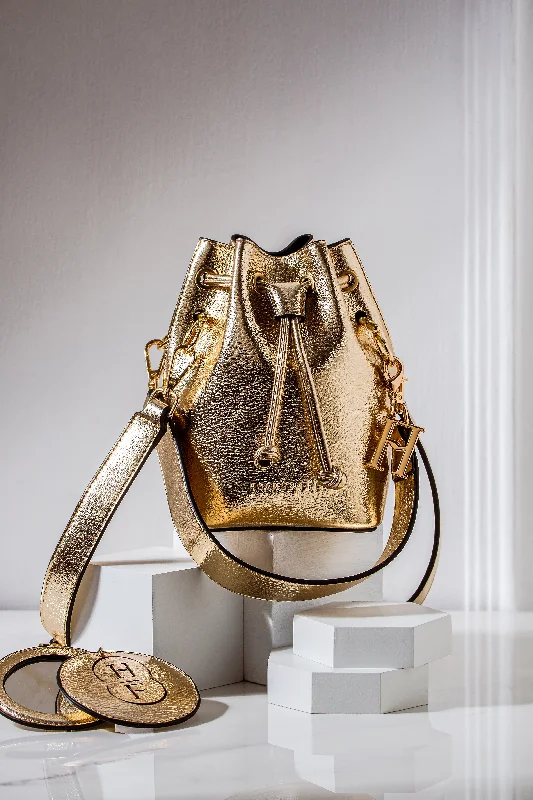 Laser - cut leather bucket bag with an intricate patternGold vegan leather bucket bag with short detachable strap and long detachable body strap Only